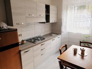 a kitchen with white cabinets and a table and a stove at CA del CARMINE in Florence
