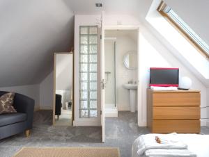 een woonkamer met een wastafel en een spiegel bij The Annexe in Cheltenham