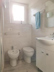 a white bathroom with a toilet and a sink at CA del CARMINE in Florence +18 photos