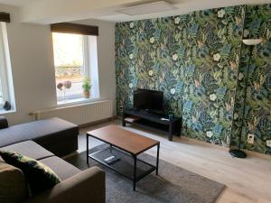 a living room with a couch and a tv and a table at Studio de Spa in Spa