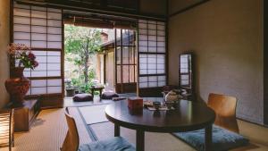 een kamer met een tafel en stoelen en een raam bij お宿梅夜Guesthouse Umeya in Kyoto