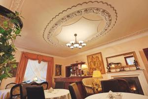 une salle à manger avec des tables, des chaises et un grand miroir dans l'établissement Dworek Genny, à Polanica-Zdrój