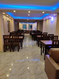 un restaurante con mesas y sillas de madera y luces azules en Pashupati View Hotel en Katmandú