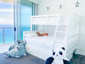 um quarto com um beliche branco com animais de peluche em Air on Broadbeach Beachfront 2Level stunning apartment with 180 degree views em Gold Coast