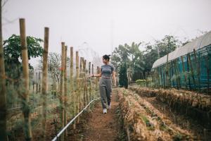 a woman walking down a dirt road next to a train at Phoomtada Homestay in Wiang Pa Pao