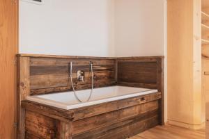 a bath tub in a room with a wooden wall at Huberhof in Völs am Schlern