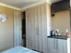 um quarto com um armário de madeira e uma cama em Sgobolo Guest House em Calcutta