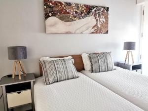 a bedroom with two beds and a painting on the wall at Unique Apartment Milfontes - Duna Parque Resorts & Hotels in Vila Nova de Milfontes +24 photos