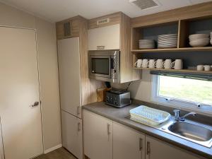 a kitchen with a sink and a microwave at Paul’s place silversands in Lossiemouth