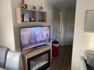 ein Wohnzimmer mit einem Flachbild-TV auf einem Tisch in der Unterkunft Paul’s place silversands in Lossiemouth