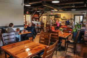 Eine Gruppe von Menschen sitzt an Tischen in einem Restaurant in der Unterkunft Old Mill Inn in Hatfield
