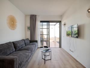 een woonkamer met een bank en een tafel bij HomeForGuest Moderno Apartamento en Corralejo in Corralejo