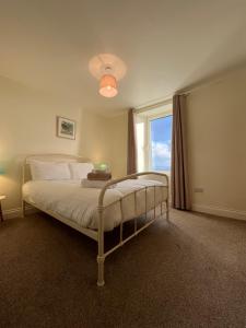 a bedroom with a large bed with a window at Old Irish farmhouse in Dingle +37 photos