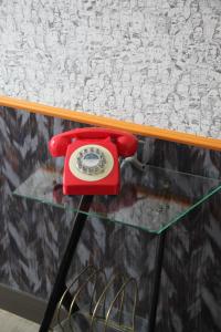 a red phone sitting on top of a glass table at Hôtel Crayon Rouge in Paris