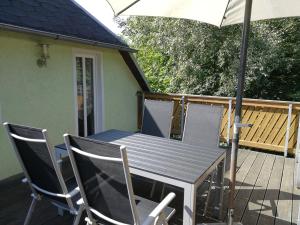 einen Tisch und Stühle mit einem Sonnenschirm auf einer Terrasse in der Unterkunft Ferienwohnung Brandmuehle in Bad Schlema