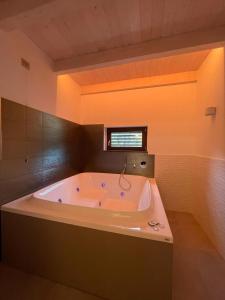 a large bath tub in a room with a window at Naturamare B&B in Villapiana +40 photos