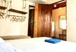 a bedroom with a bed and a wooden door at Vila Hibisco Itacaré in Itacaré