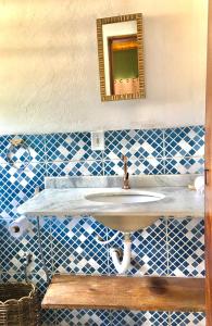 a bathroom with a sink and a mirror at Vila Hibisco Itacaré in Itacaré