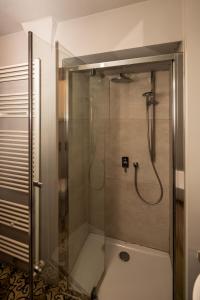 a shower with a glass door in a bathroom at Le Dimore di Piazza in Mondovì