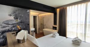 a bathroom with a bed and a tub in a room at Eurohotel Diagonal Port in Barcelona