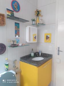 uma casa de banho com um lavatório e um armário amarelo em Verona em Paulista