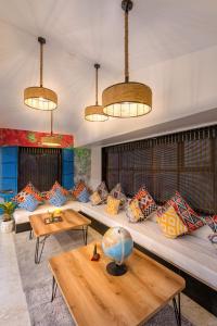 een woonkamer met een grote bank met kleurrijke kussens bij Coliwo Un - VIman Nagar in Pune