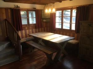 uma mesa de madeira e banco num quarto com janelas em Chalet Chouc'le em Vercorin