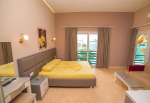 sypialnia z łóżkiem z żółtą pościelą i oknem w obiekcie Apartments Serxhio w Sarandzie
