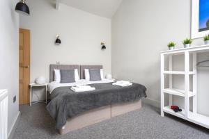 a bedroom with a bed with two towels on it at Oxford Passage Coach House in Cheltenham