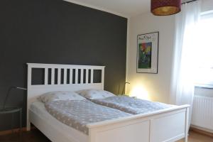 a bedroom with a white bed with a white headboard at Ferienwohnung Arenz in Schweinfurt