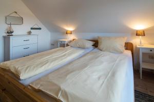 a large bed in a bedroom with two pillows at Deichhaus in Neßmersiel