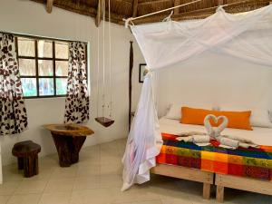 
a bedroom with a bed and a canopy canopy at Villa Morena Boutique Hotel Ecoliving in Akumal
