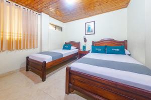 a bedroom with two beds and a window at Ayenda Pakande in Popayan
