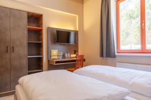 Łóżko lub łóżka w pokoju w obiekcie JUFA Hotel Mariazell