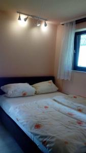 1 dormitorio con 1 cama con 2 almohadas y ventana en Ferienwohnung Kling en Bischofsheim an der Rhön