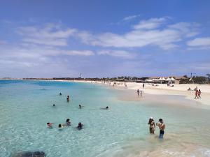 a group of people in the water at a beach at AH - Vila Verde Private Apartment in Santa Maria