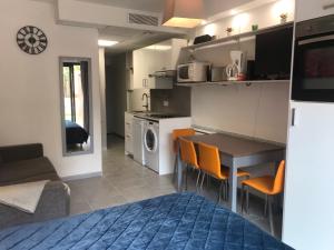 a kitchen and living room with a table and chairs at SOPHIES HOMES FÉLIBRIGES BEACH & PALAIS des FESTIVALS in Cannes +8 photos