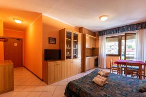 Cet appartement comprend une chambre avec un lit, une télévision et une cuisine. dans l'établissement Residence Saint-Vincent, à Saint-Vincent