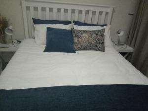 a bed with blue and white pillows on it at Private Room Chez Khanyi Homestays in Pretoria