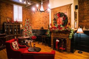 a living room with christmas trees and a fireplace at The Historic Brookstown Inn, Trademark Collection by Wyndham in Winston-Salem
