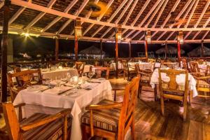 uma sala de jantar com mesas e cadeiras brancas em Royal Decameron Club Caribbean Resort - All Inclusive em Runaway Bay