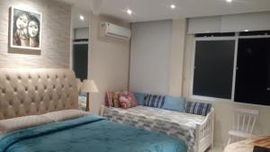 Un dormitorio con una cama y un sofá y una ventana. en Copaestilo, en Río de Janeiro