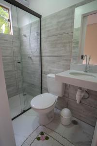 a bathroom with a shower and a toilet and a sink at Diver Village Ilhabela in Ilhabela