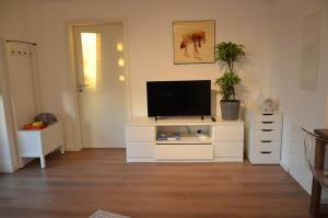 a living room with a tv on a white cabinet at Ferienwohnung Bad Fredeburg in Schmallenberg