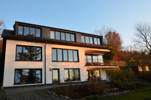 ein großes weißes Haus mit schwarzen Fenstern in der Unterkunft Ferienwohnung Bad Fredeburg in Schmallenberg