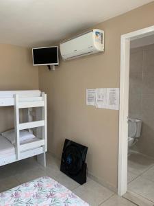 a room with a toilet and a air conditioner on the wall at Apto e Suítes Praia do Itapocoroi in Penha