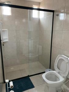 La salle de bains est pourvue d'une douche et de toilettes. dans l'établissement Apto e Suítes Praia do Itapocoroi, à Penha