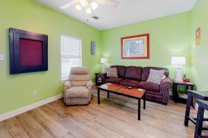 a living room with a couch and a chair at Plum Cute by Meyer Vacation Rentals in Gulf Shores