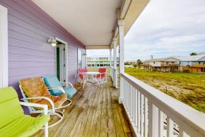 a porch with chairs and a table on it at Plum Cute by Meyer Vacation Rentals in Gulf Shores