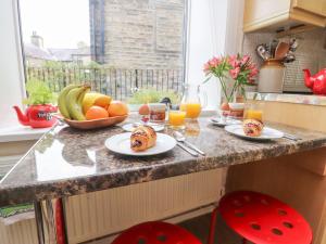 a kitchen counter with plates of food and fruit at Heather Corner in Keighley